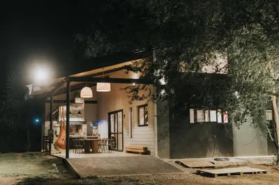 a small building with a porch at night at Casa Brunia Lago Los Molinos in Villa General Belgrano