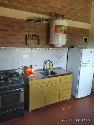 a kitchen with a sink and a stove and refrigerator at Departamento CatyDay in Mina Clavero