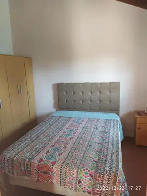 a bedroom with a bed with a quilt on it at Departamento CatyDay in Mina Clavero