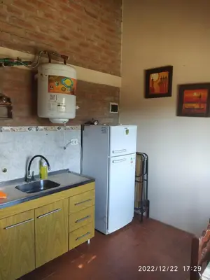 a kitchen with a white refrigerator and a sink at Departamento CatyDay in Mina Clavero