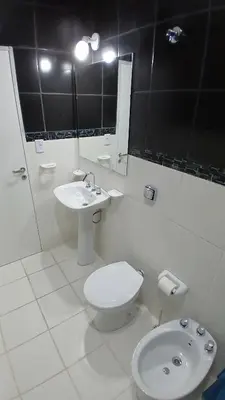 a white bathroom with a toilet and a sink at LOS BULGAROS in Villa Cura Brochero