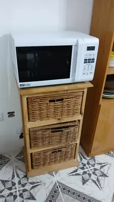 a microwave sitting on top of a table with baskets at LOS BULGAROS in Villa Cura Brochero