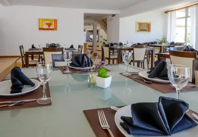a dining room with a table with plates and glasses at Hotel La Huertita in Libertador General San Martín
