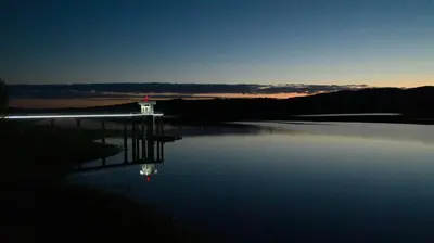 a lighthouse on a body of water at sunset at Hotel La Huertita in Libertador General San Martín