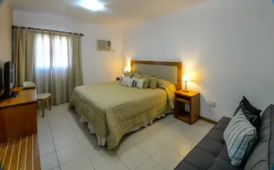a hotel room with a bed and a couch at Hotel La Huertita in Libertador General San Martín