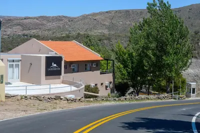 a house with an orange roof on the side of a road at Hotel La Huertita in Libertador General San Martín
