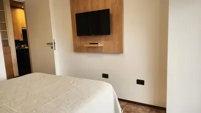 a bedroom with a bed and a television on a wall at Centro Av General Paz 418 Estacionamiento economico in Cordoba