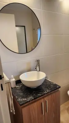a bathroom with a bowl sink and a mirror at Centro Av General Paz 418 Estacionamiento economico in Cordoba