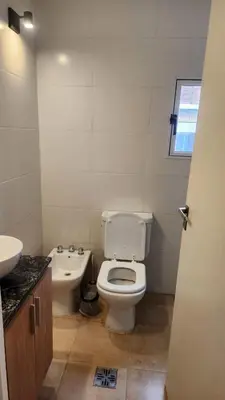 a bathroom with a white toilet and a sink at Centro Av General Paz 418 Estacionamiento economico in Cordoba