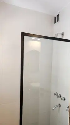 a bathroom with a shower with a glass door at Centro Av General Paz 418 Estacionamiento economico in Cordoba