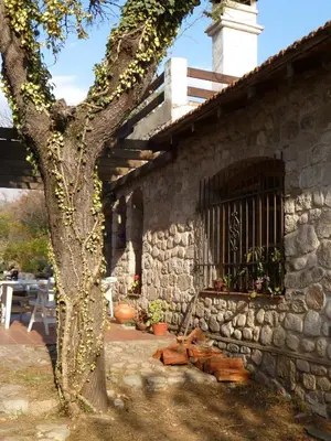 a stone building with a tree in front of it at Casa Soleares in Villa de Las Rosas
