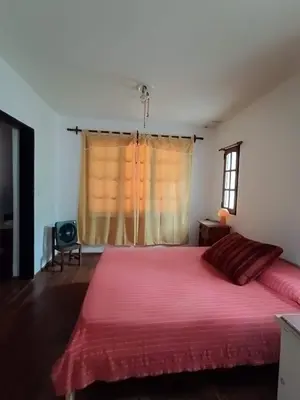 a bedroom with a large red bed with a window at Casa Soleares in Villa de Las Rosas