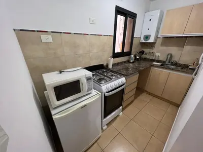 a small kitchen with a stove and a microwave at Castel Di Lucio 6 - Pleno centro Cba - in Cordoba