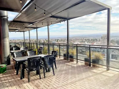 a patio with tables and chairs on a balcony at Torre Leonardo Carlos Paz in Villa Carlos Paz