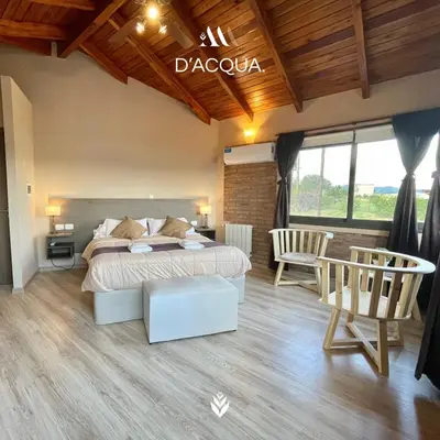 a bedroom with a bed and chairs in a room at Agrippina in Villa Carlos Paz