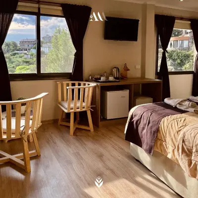 a bedroom with a bed and a desk and two chairs at Agrippina in Villa Carlos Paz