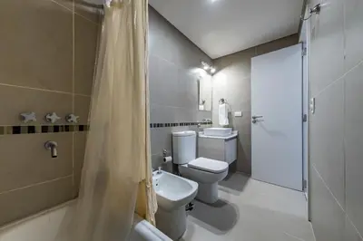 a bathroom with a toilet and a sink and a shower at Edificio Opera en Villa Carlos Paz - Pileta en Terraza e increíbles vistas in Villa Carlos Paz