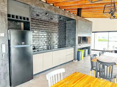 a kitchen with a refrigerator and a table and chairs at Don Francisco Apartamentos in Villa Carlos Paz