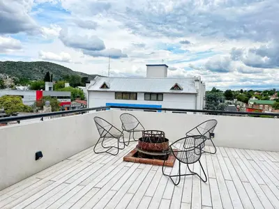 a patio with chairs and a table on a roof at Don Francisco Apartamentos in Villa Carlos Paz