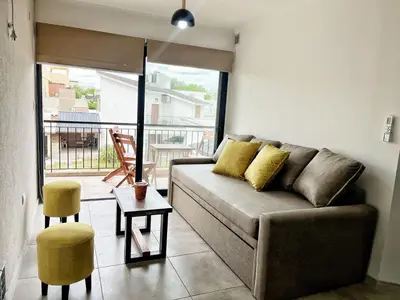 a living room with a couch and a balcony at Don Francisco Apartamentos in Villa Carlos Paz