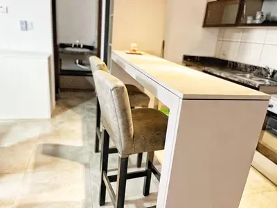 a kitchen with two bar stools at a counter at Don Francisco Apartamentos in Villa Carlos Paz