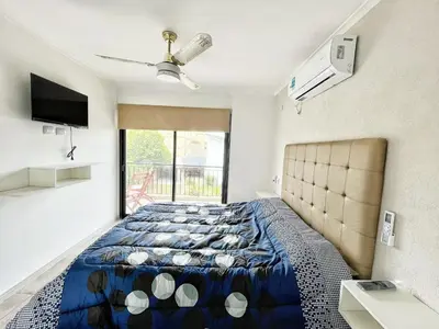 a bedroom with a bed and a large window at Don Francisco Apartamentos in Villa Carlos Paz