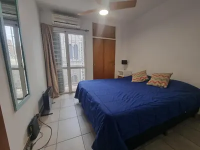 a bedroom with a blue bed and a window at Departamento en el corazón de Guemes! in Cordoba