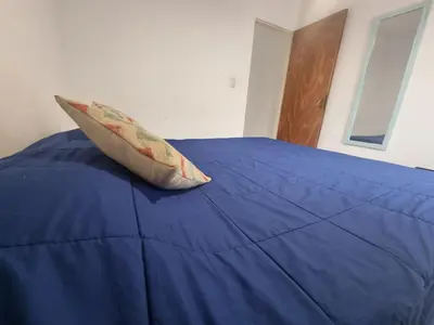 a pillow sitting on top of a blue bed at Departamento en el corazón de Guemes! in Cordoba