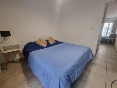 a bedroom with a bed with blue sheets and pillows at Departamento en el corazón de Guemes! in Cordoba