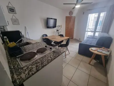 a kitchen and living room with a table and a couch at Departamento en el corazón de Guemes! in Cordoba
