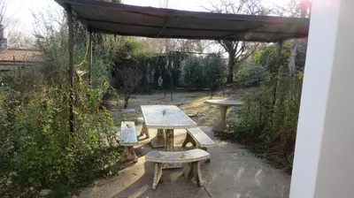 a picnic table and bench in a garden at La Candelaria in Santa Rosa de Calamuchita