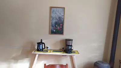 a table with two coffee makers and a picture on the wall at La Candelaria in Santa Rosa de Calamuchita