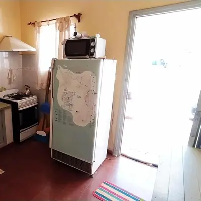 a microwave on top of a refrigerator in a kitchen at La Candelaria in Santa Rosa de Calamuchita