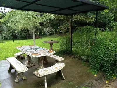 a picnic table and benches under an umbrella at La Candelaria in Santa Rosa de Calamuchita