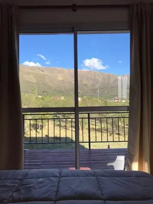 a bedroom with a bed and a large window at Mirador Merlo in Merlo