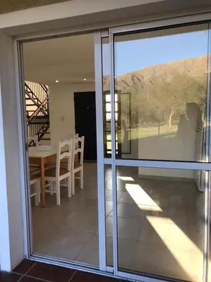 a sliding glass door leading to a patio with a table at Mirador Merlo in Merlo