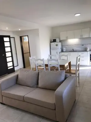 a living room with a couch and a table and a kitchen at Mirador Merlo in Merlo