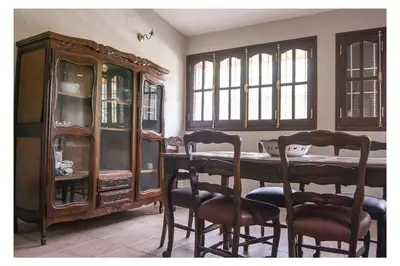 a dining room with a table and chairs and a cabinet at VILLA BEATRIZ in Villa Anizacate