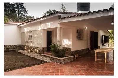 a small white house with a brick patio at VILLA BEATRIZ in Villa Anizacate
