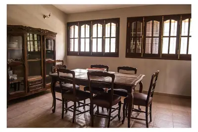 a dining room with a wooden table and chairs at VILLA BEATRIZ in Villa Anizacate