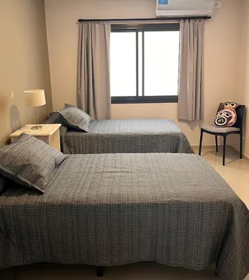two beds in a bedroom with a window at Depto Tatiana zona céntrica Carlos Paz in Villa Carlos Paz