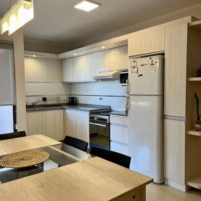 a kitchen with a white refrigerator and a table at Depto Tatiana zona céntrica Carlos Paz in Villa Carlos Paz