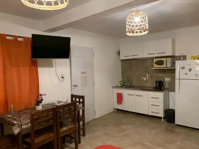 a small kitchen with a table and a refrigerator at Posada The Gringos in Villa Yacanto