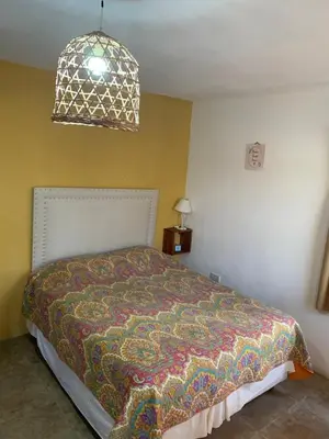 a bedroom with a bed with a colorful blanket at Posada The Gringos in Villa Yacanto