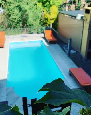a swimming pool with two red chairs and sidx sidx sidx at Posada The Gringos in Villa Yacanto