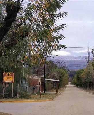 a dirt road with a sign on the side of the road at Posada The Gringos in Villa Yacanto