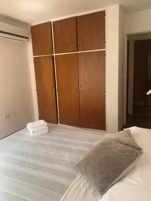 a bedroom with a large bed with wooden cabinets at Estancia Nueva Córdoba in Cordoba