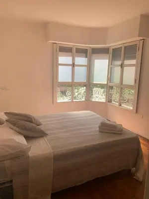 a bedroom with two beds and two windows at Estancia Nueva Córdoba in Cordoba