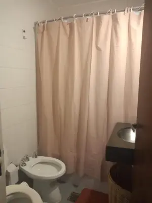 a bathroom with a toilet and a shower curtain at Estancia Nueva Córdoba in Cordoba
