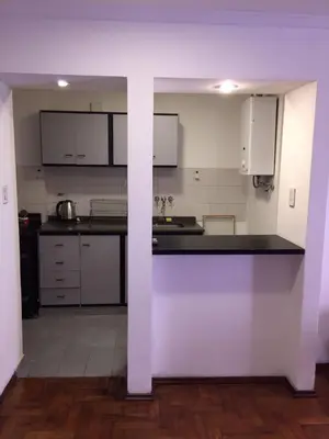 a kitchen with white cabinets and a black counter top at Estancia Nueva Córdoba in Cordoba